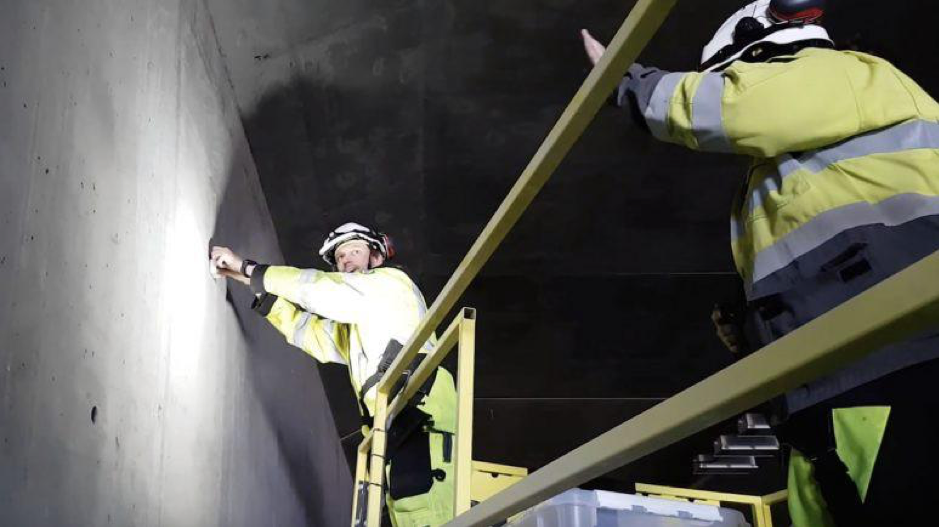 Dos personas instalan aparatos de Waze en túnel, bajo el concepto de Smart City.