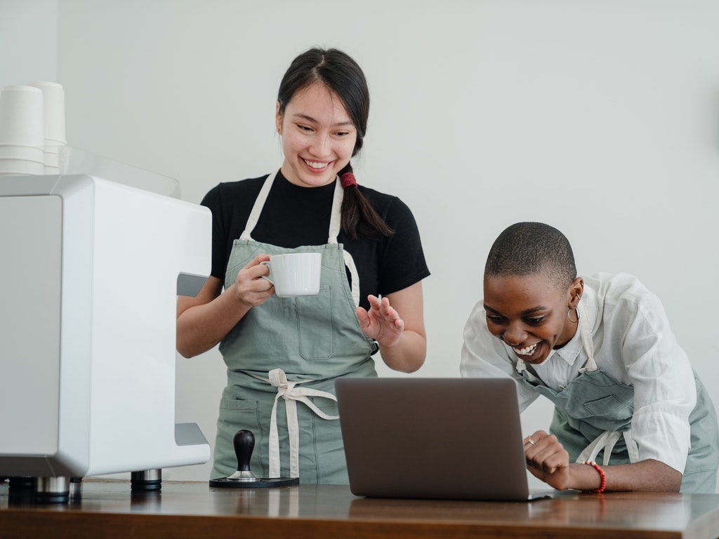Dos personas felices frente a un computador.